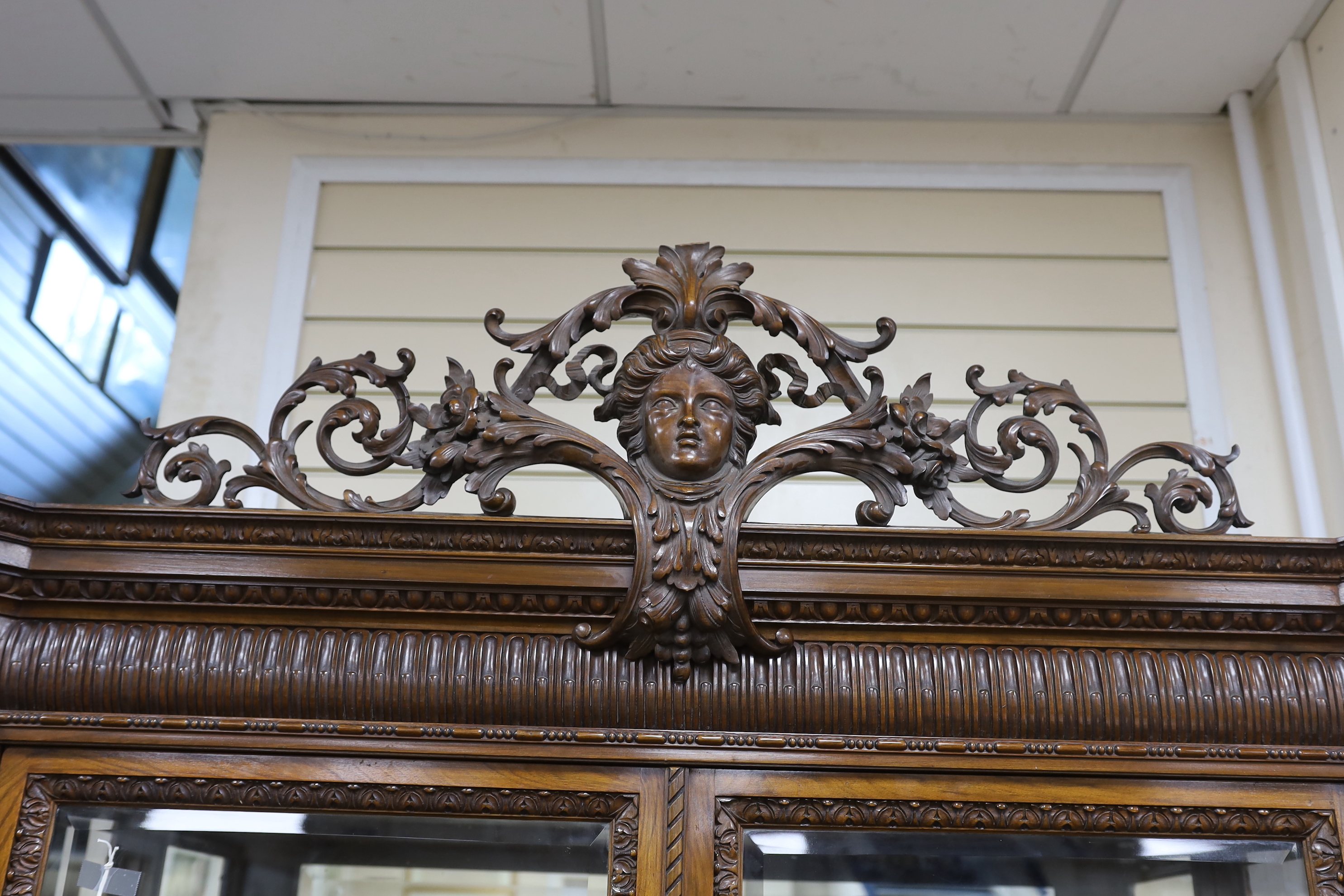 An early 20th century George I style carved walnut vitrine, width 138cm, depth 50cm, height 218cm